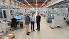  – Stefan van Aalst, OPEN&nbsp;MIND, Olaf Heijers and Johan van den Heuvel (from left to right) in the modern, automated workshop at Kusters Precision Parts. The <em>hyper</em>MILL<sup>®</sup> programming stations can be seen in the background. </br><em>Image: Kusters Precision Parts</em>
